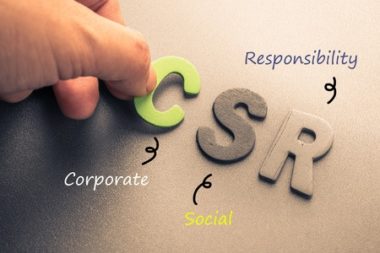 closeup hand arrange wood letters as csr abbreviation(corporate social responsibility)