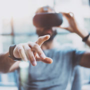 closeup of male hand.bearded young man wearing virtual reality goggles in modern coworking studio. smartphone using with vr headset in office. horizontal, blurred