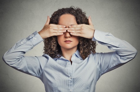 closeup portrait headshot young woman closing covering eyes with hands can't look hiding avoiding situation isolated grey wall background. see no evil concept. human emotion face expression perception