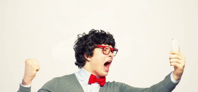 young businessman with a red tie shouting furiously at his mobile phone