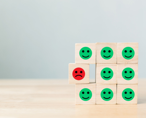 group of smiley faces with one frowning face