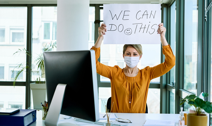 Businesswoman holding placard with we can do this text as support during virus epidemic.