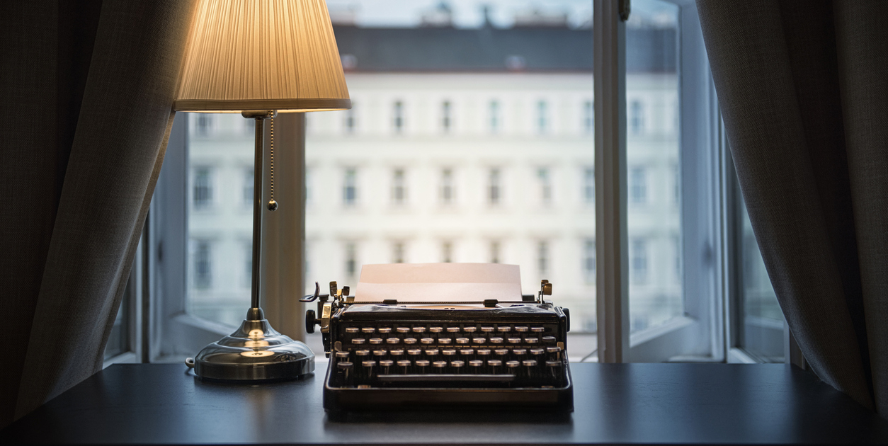 An old typewriter and a lamp on the table.