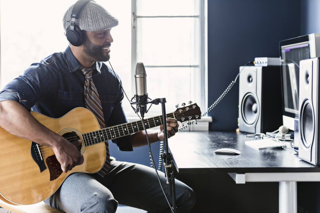 A man recording his music in his home studio.