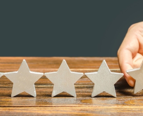 hand setting down 5th star on wood table