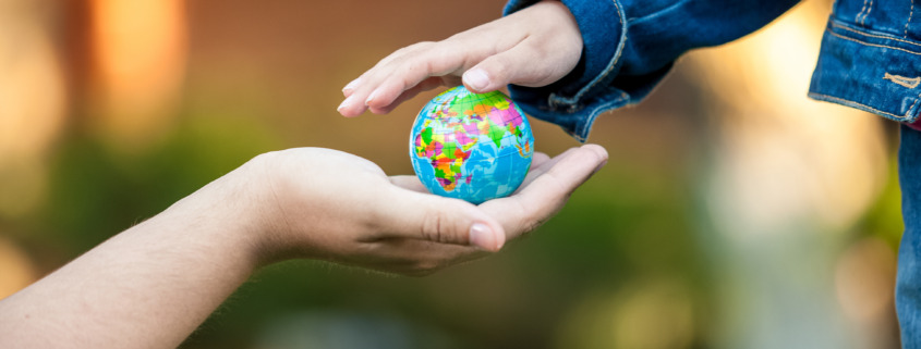 man giving little girl globe