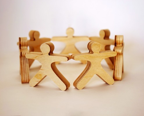 wood model of people connected in a circle