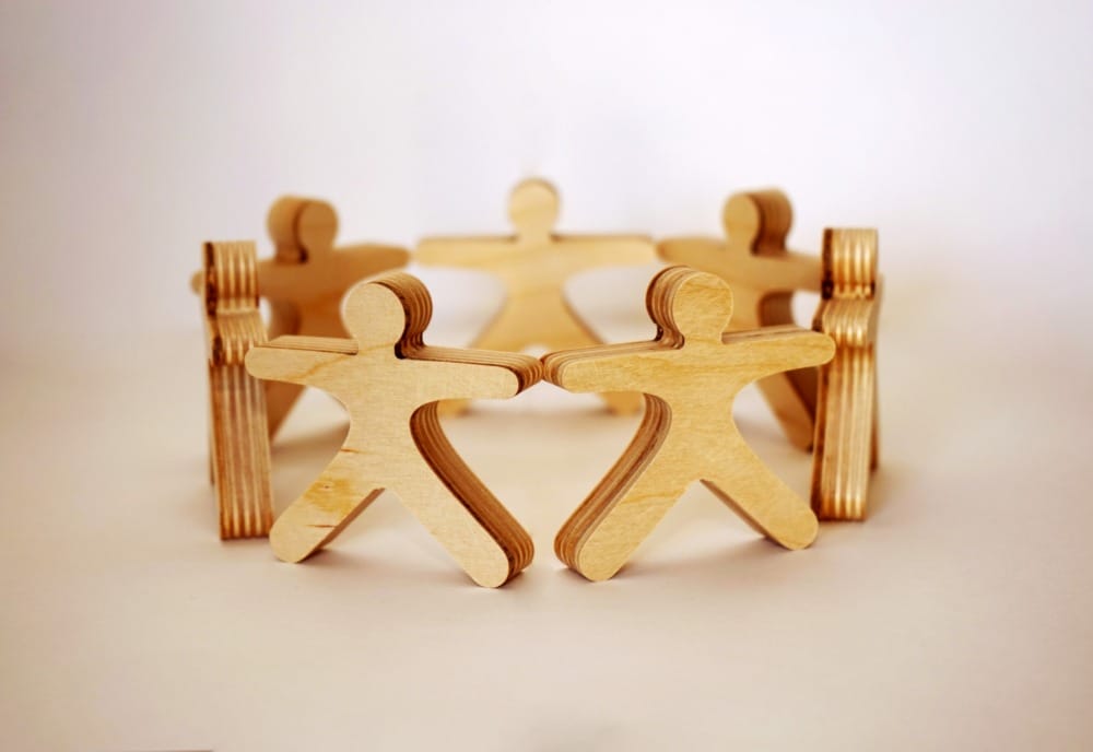 wood model of people connected in a circle
