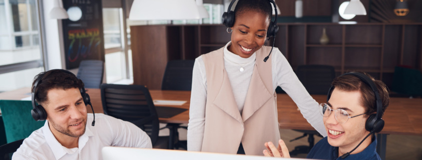 call center employees gathered around computer