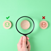 magnifying glass between happy and sad faces