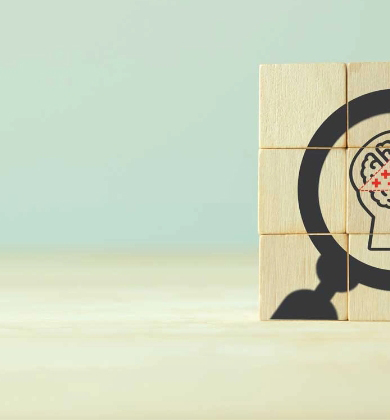 stacked wood block puzzle with magnifying glass icon around brain icon