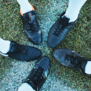 five soccer shoes with toes touching