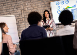 Young businesswoman holding presentation to diverse group of people