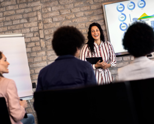 Young businesswoman holding presentation to diverse group of people