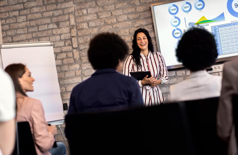 Young businesswoman holding presentation to diverse group of people