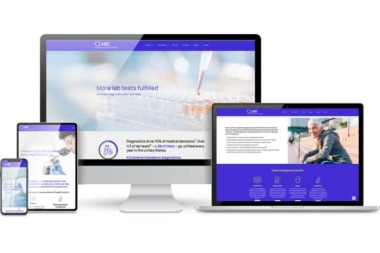 A smart phone and tablet are on the left with a monitor in the center and a laptop on the right. All four are showing a responsive website.
