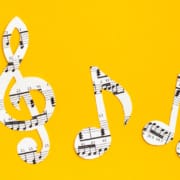 Musical notes and clef cut from paper with musical text in a row