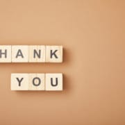 top view of wooden cubes with thank you lettering on beige background with copy space