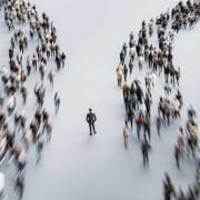 Two lines of people flowing past a business person in the middle.