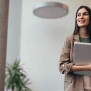 Confident, professional woman holding laptop and looking to her right