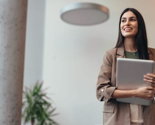 Confident, professional woman holding laptop and looking to her right