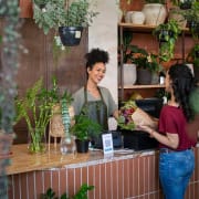 smiling female florist selling a customer flowers