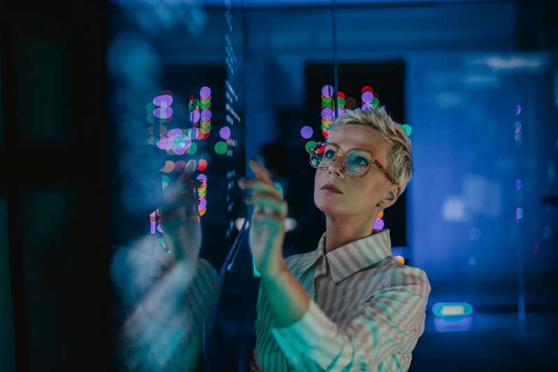 woman interacting with data displayed on a giant screen