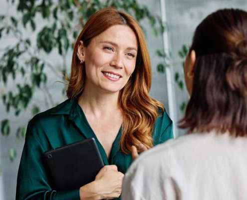 woman smiling while listening to colleague
